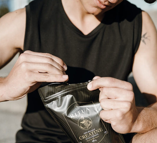 Man in training gear opening a 300g pouch of Ritua Creatine Monohydrate