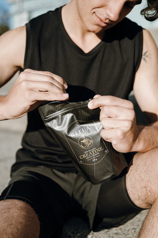 Man in training gear opening a 300g pouch of Ritua Creatine Monohydrate