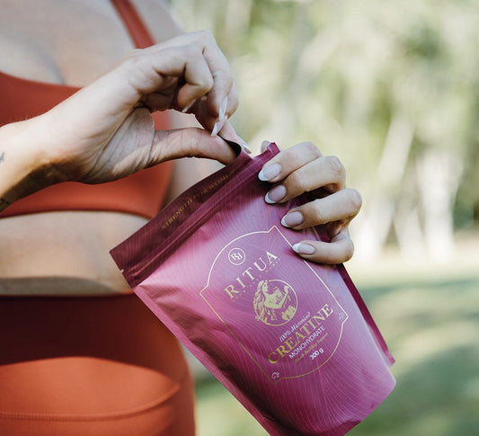Close up of creatine powder being poured from a Ritua pouch into a shaker