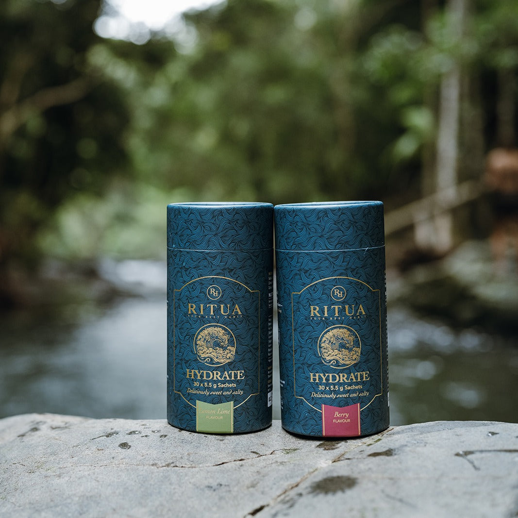 Ritua Hydrate Electrolytes, Lemon Lime and Berry tubes on a rock by a rainforest creek