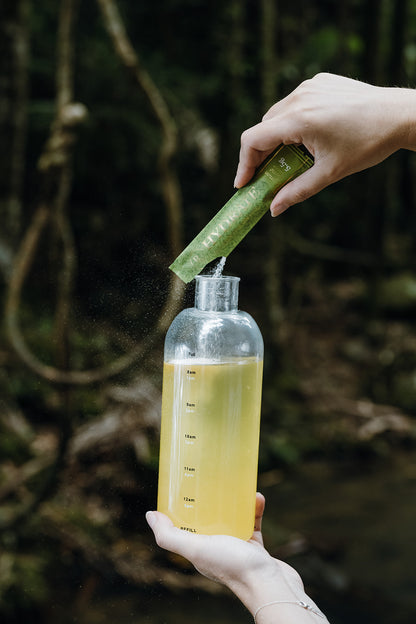 Ritua Hydrate Lemon Lime being poured into the 500ml Ritua drink bottle, showing the hourly time markings